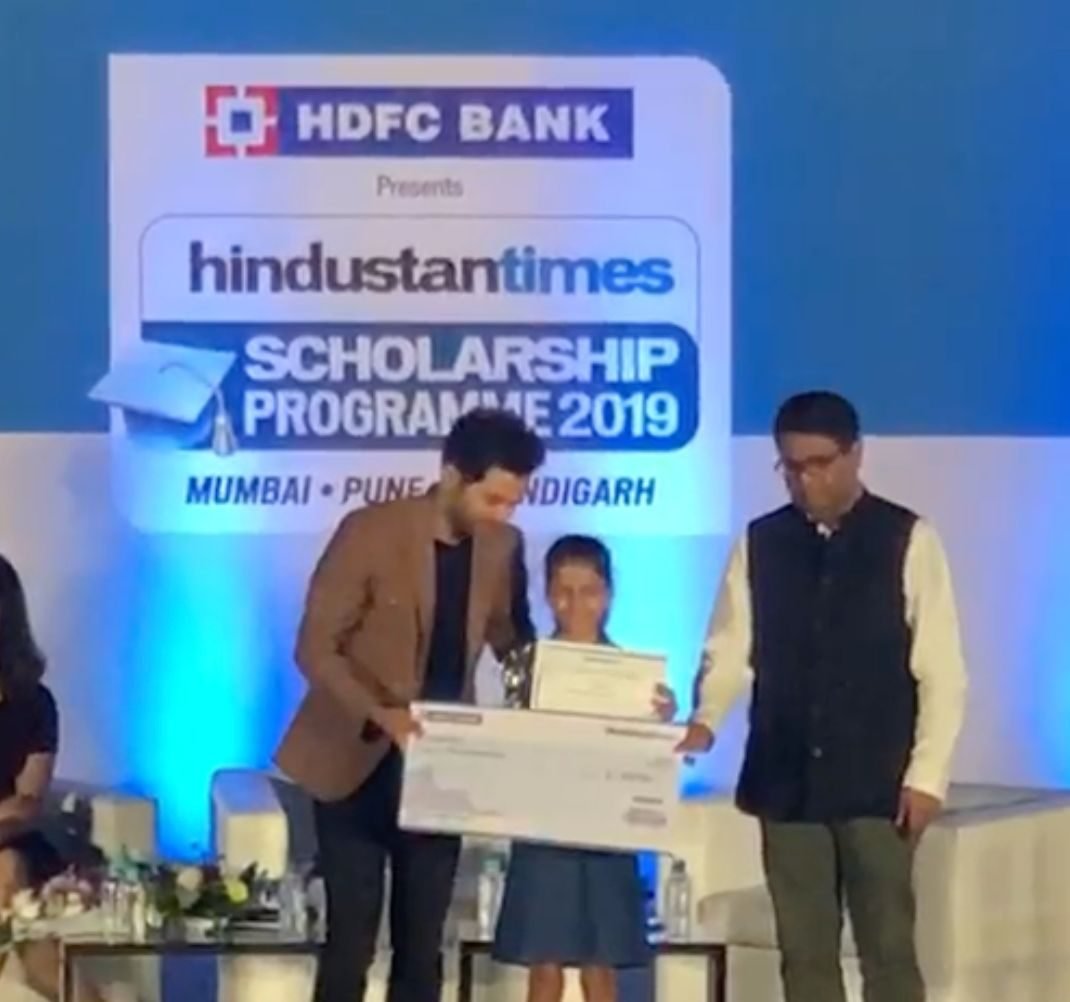 Ariana receiving the scholarship cheque on stage